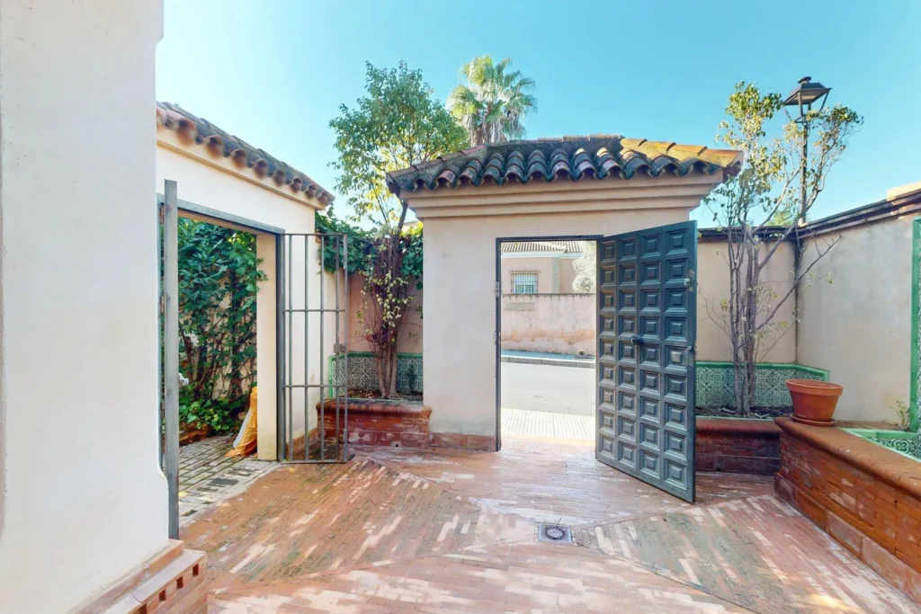 Patio de entrada con puerta principal en chalet en venta en Dehesa Golf, Huelva