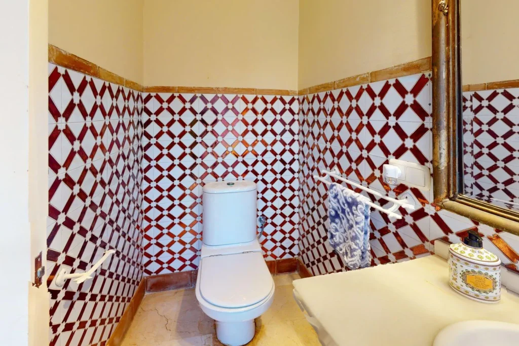 Aseo de cortesía con azulejería decorativa en chalet en Dehesa Golf, Huelva