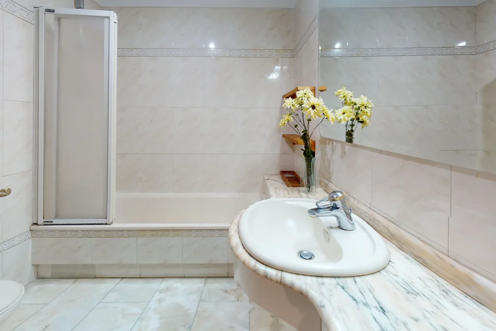 Baño con acabados en mármol en piso señorial de República Argentina, Sevilla