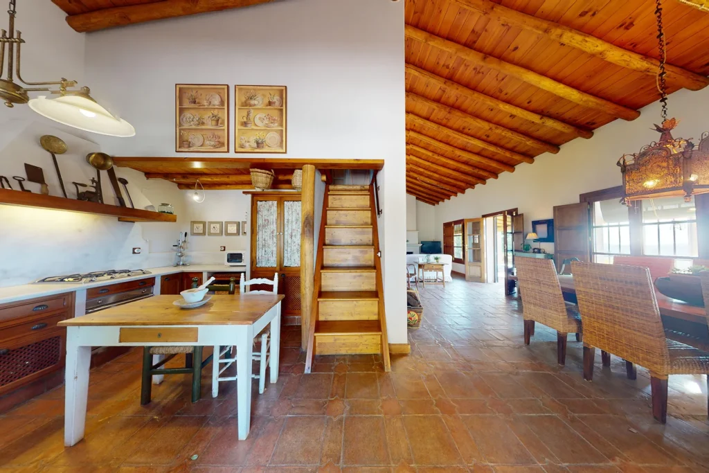 Cocina rústica con zona de comedor en casa de Higuera de la Sierra, Huelva