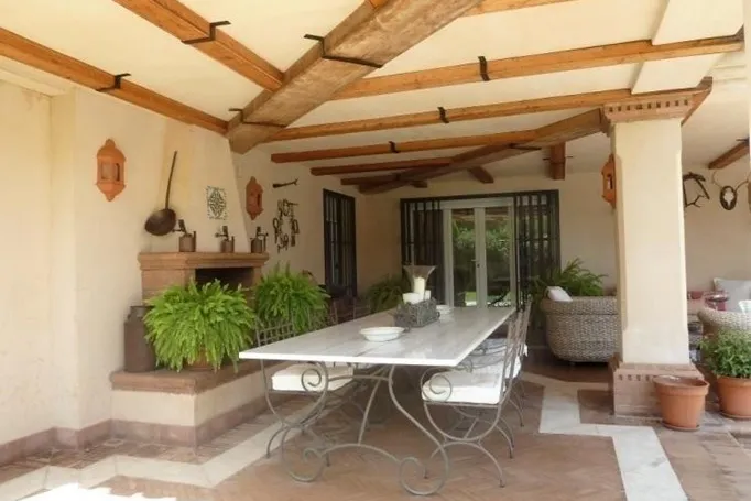 Porche cubierto con comedor exterior en chalet en venta en Dehesa Golf, Huelva