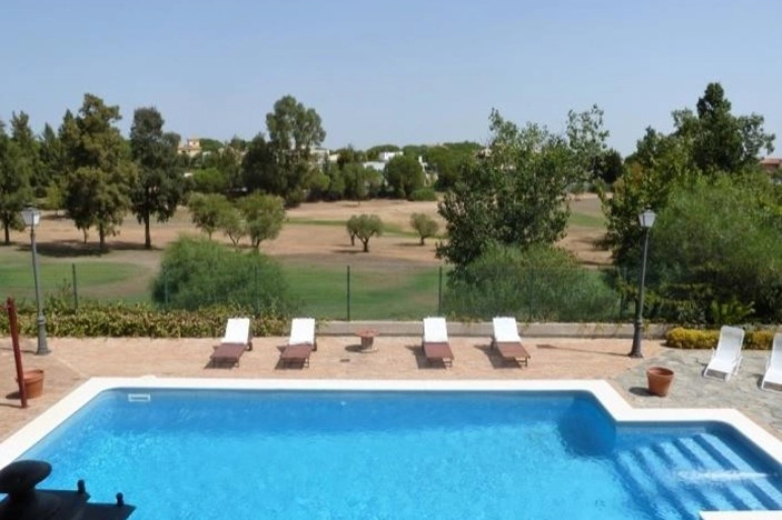 Piscina con vistas al campo de golf en chalet en Dehesa Golf, Huelva