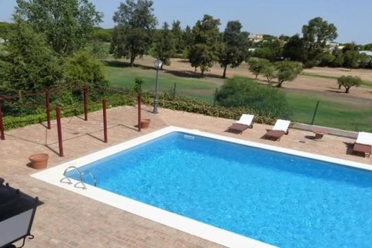 Piscina privada con zona de solárium en chalet en venta en Dehesa Golf, Huelva
