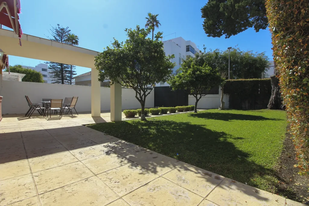 Fachada posterior con terraza y jardín privado en chalet pareado en Rota